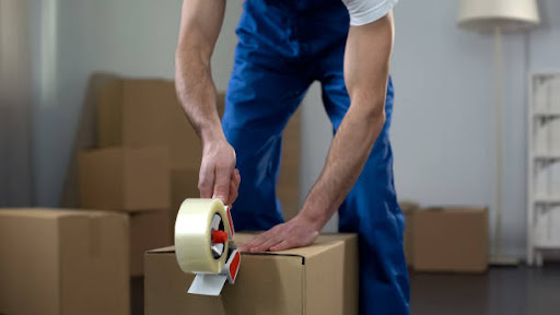Moving company workers packing cardboard